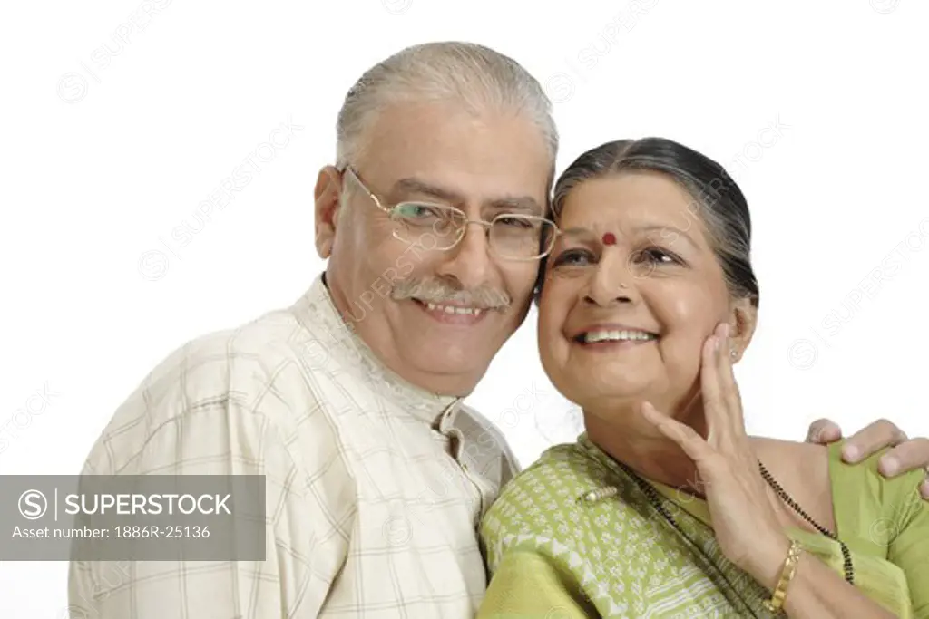 Old happy couple, old man wearing Kurta Pajama, specs, glasses old lady wearing light green coloured Gujrathi style Saree, Mangalsutra, Nose ring or stud, Saree pin, earrings, both standing close to each other, touching each others heads, man kept his left hand on her left shoulder, lady looking up with touching her left hand to her chick smiling, MR # 703A and 703B