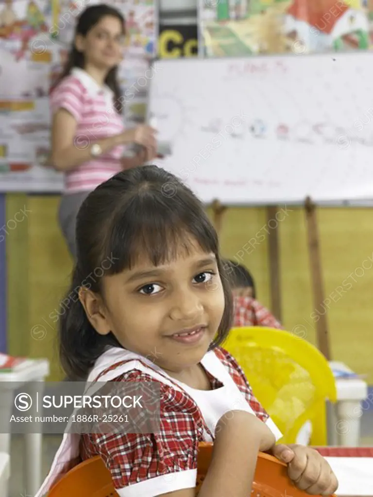 South Asian Indian girl looking behind in nursery school MR
