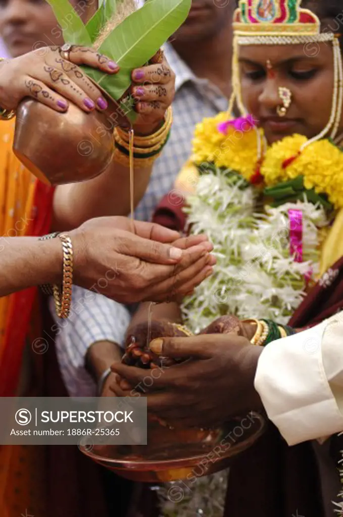 Indian Hindu bride and bridegroom performing kanyadan vidhi in marriage ceremony ; Bombay Mumbai ; Maharashtra ; India MR705V