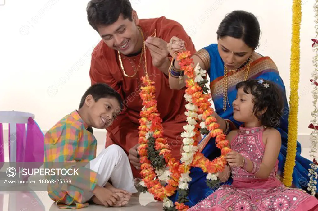 Maharashtrian parent with children holding garland on diwali festival MR#716E;716F;716G;716H