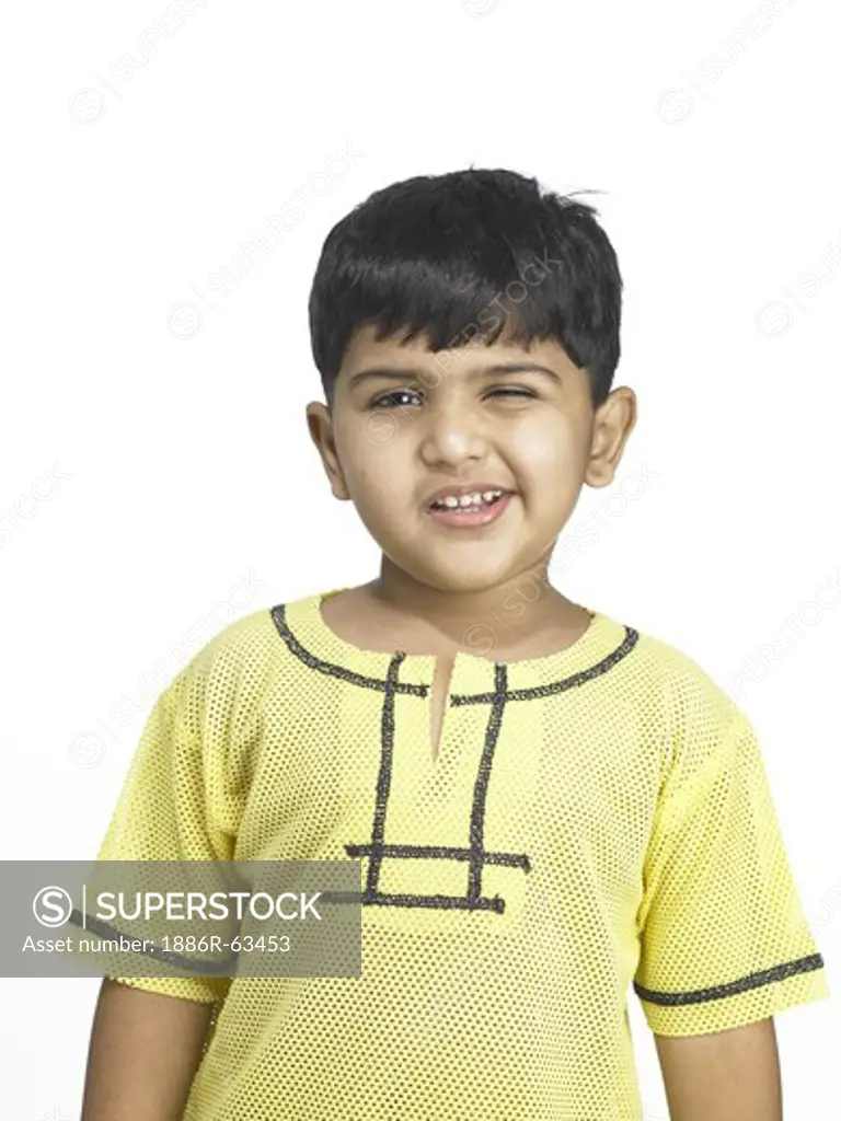 South Asian Indian boy making funny face in nursery school MR winking