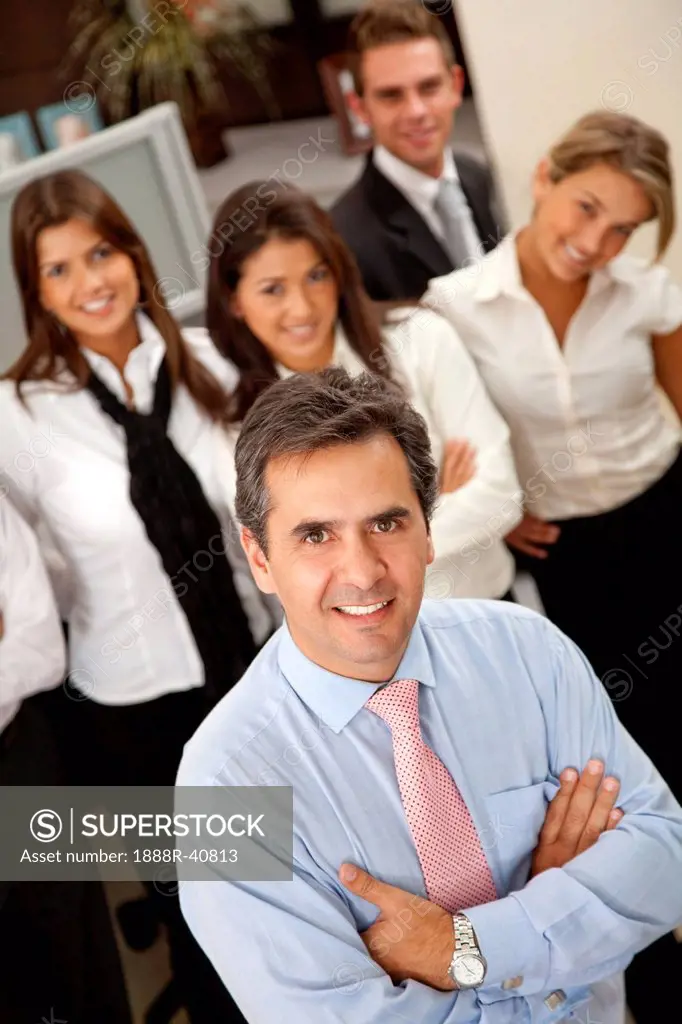 Business man at the office with a group behind