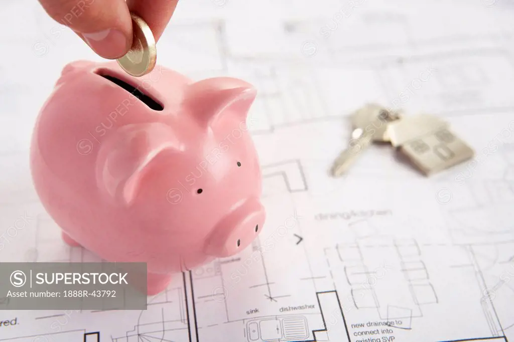 Piggybank with house plans and keys