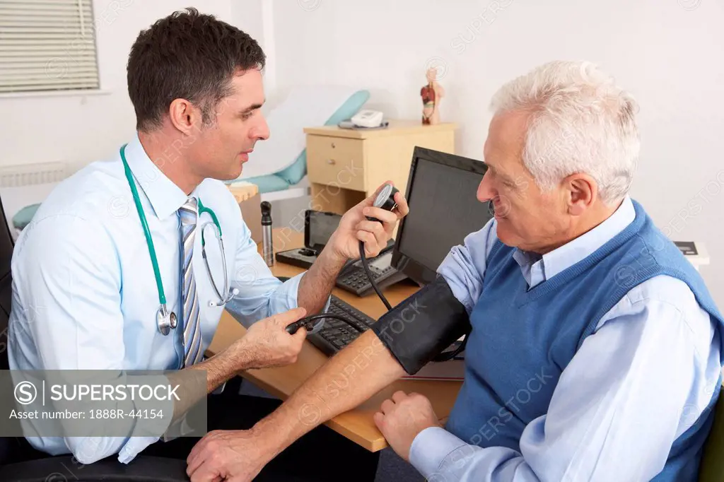 British doctor taking senior man´s blood pressure