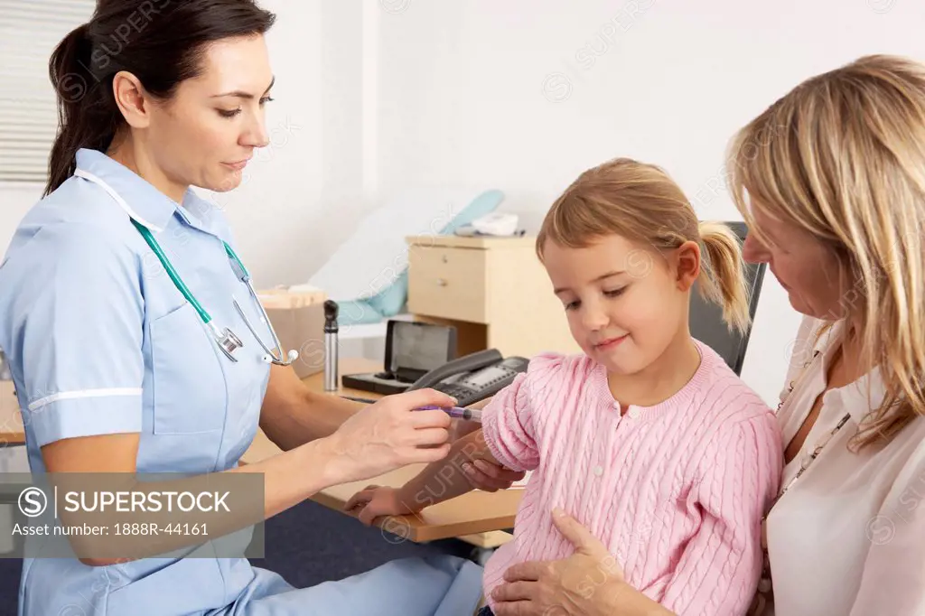 British nurse giving injection to young child