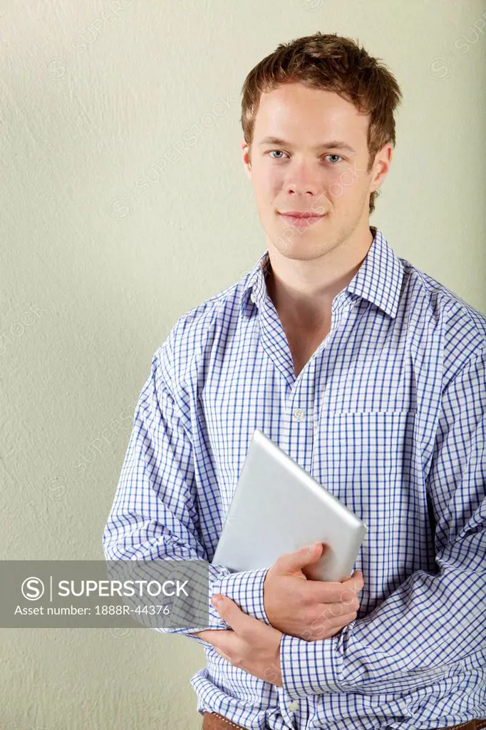 Studio Shot Of Young Man Holding Tablet Computer