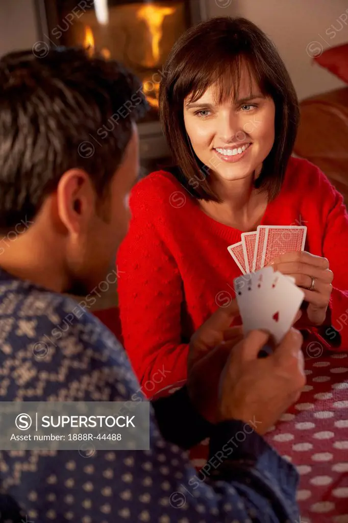 Couple Playing Cards By Cosy Log Fire