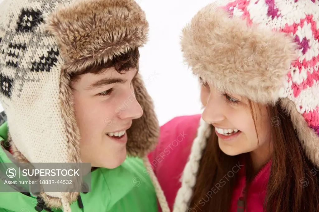 Teenage Couple In Snow Wearing Fur Hats