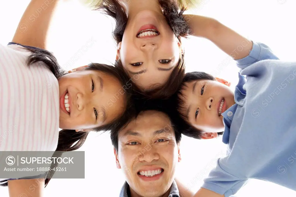 Young Chinese Family Looking Down Into Camera
