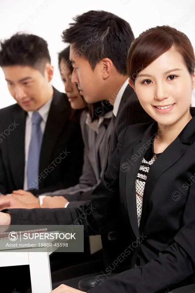 Studio Shot Of Chinese Businesspeople Having Meeting