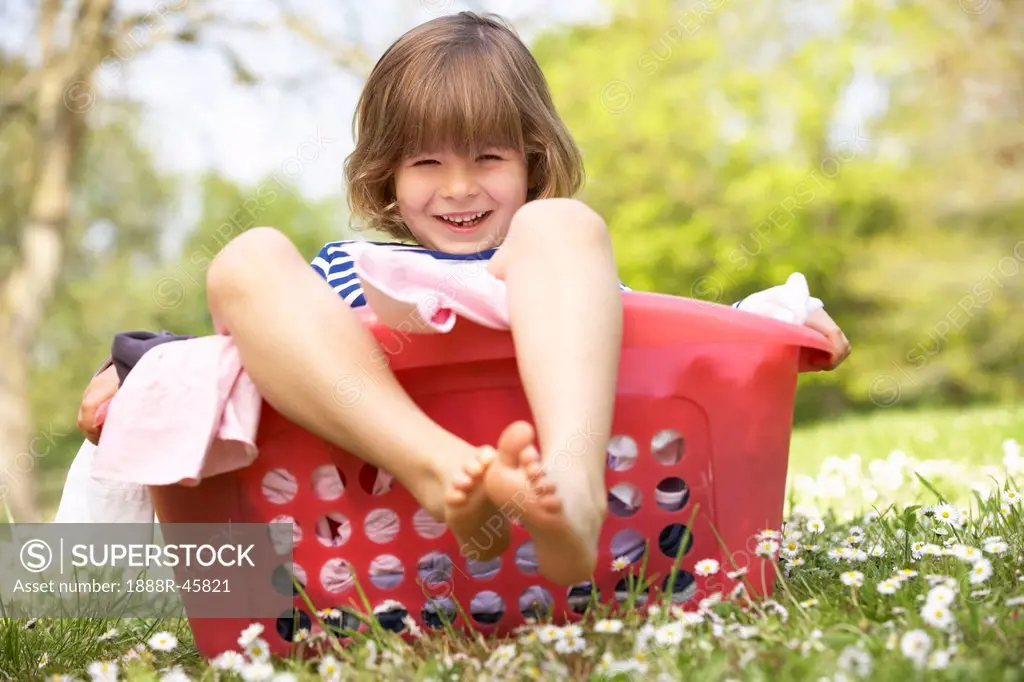 Young Boy Sitting In Laundry Basket
