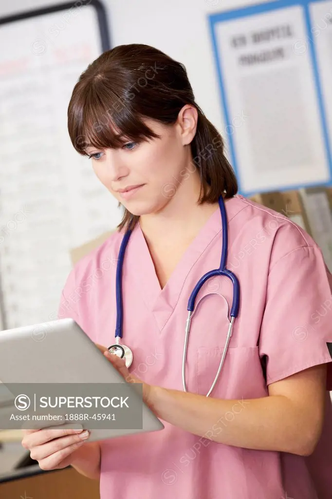 Nurse Using Digital Tablet At Nurses Station