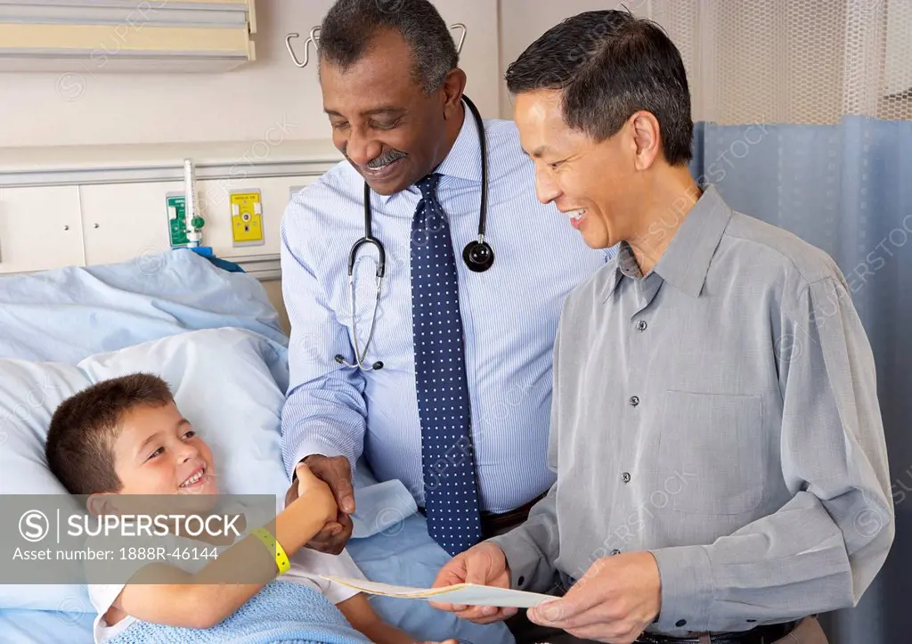 Doctors Visiting Child Patient On Ward