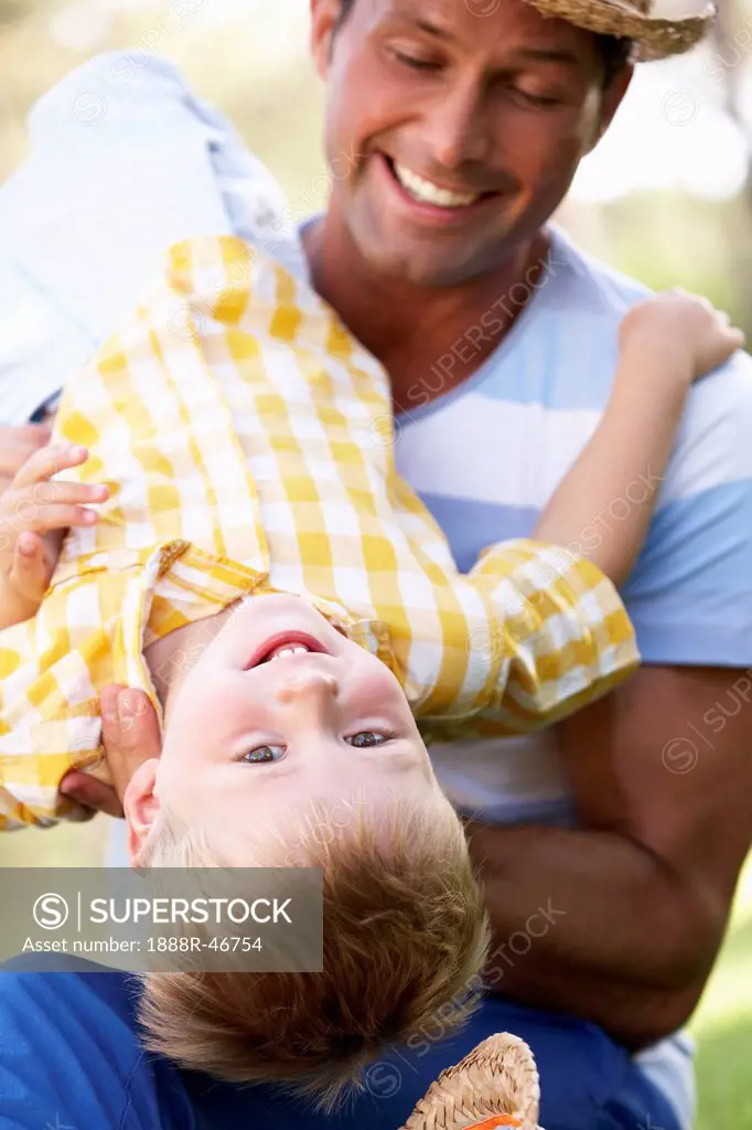 Father And Son Playing In Summer Garden