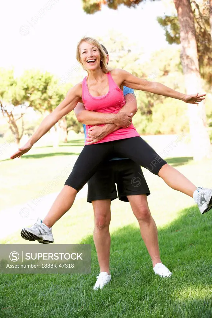 Senior Man Lifting Woman During excercise,fitness, In Park