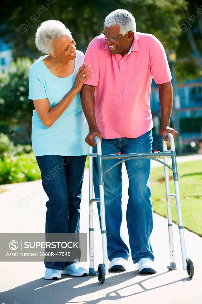 Senior Woman Helping Husband With Walking Frame