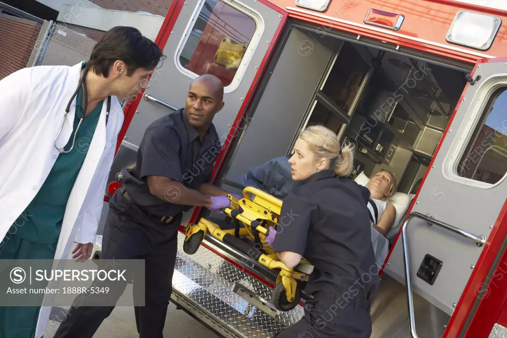 Paramedics and doctor unloading patient from ambulance