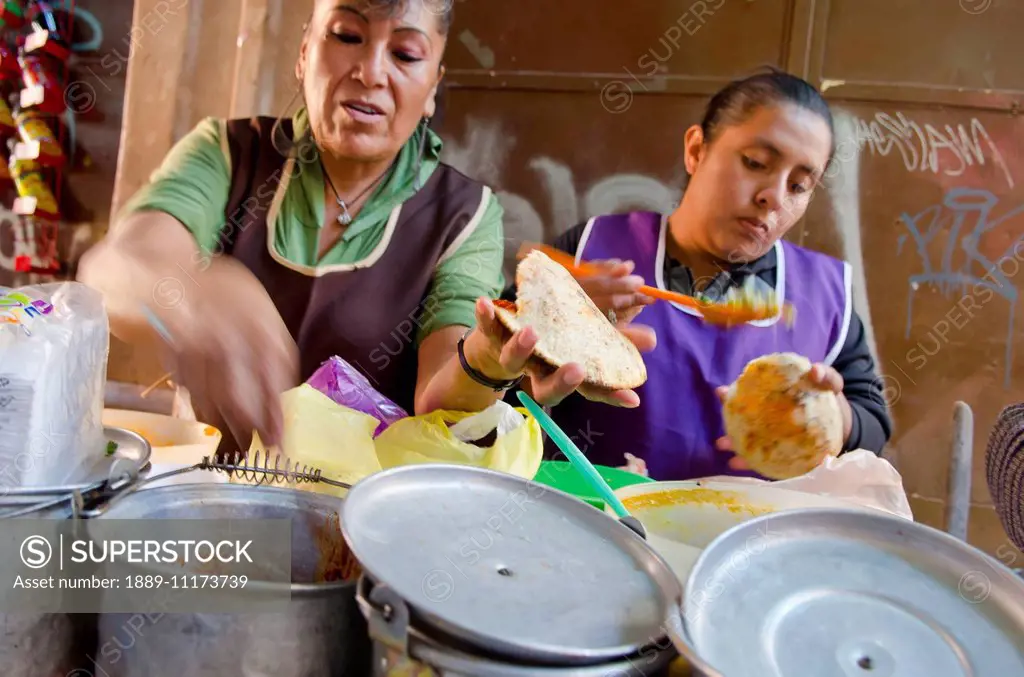 Two women working at a food stand making gorditas; San Luis de la Paz, Guanajuato, Mexico