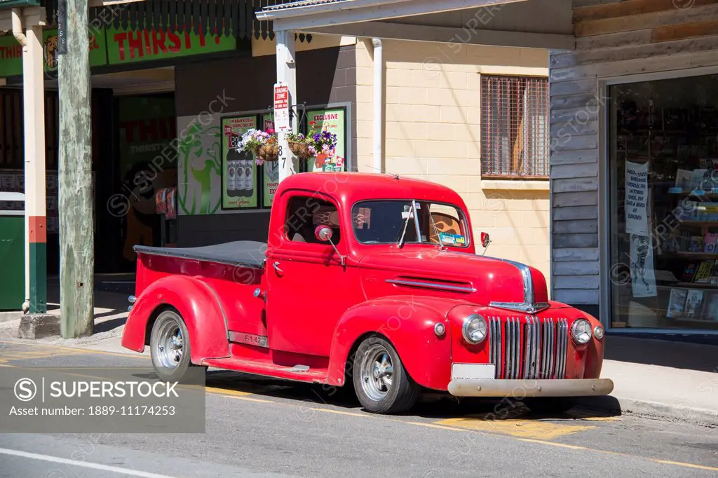Vintage red truck parked on the side of a street; Queensland, Australia