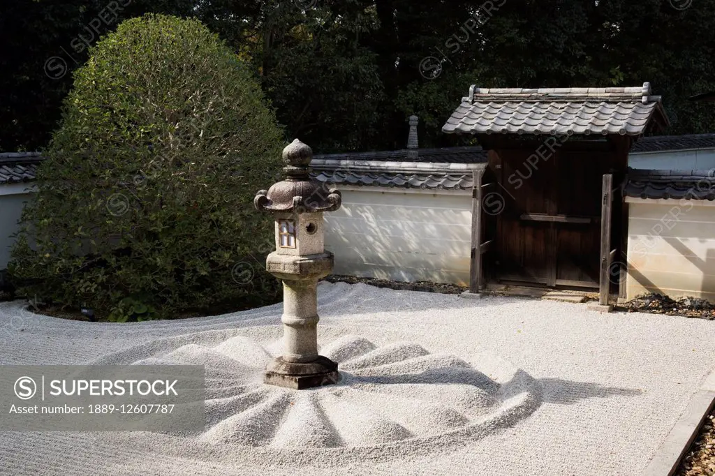 Japanese stone lantern in white gravel courtyard; Kyoto, Japan