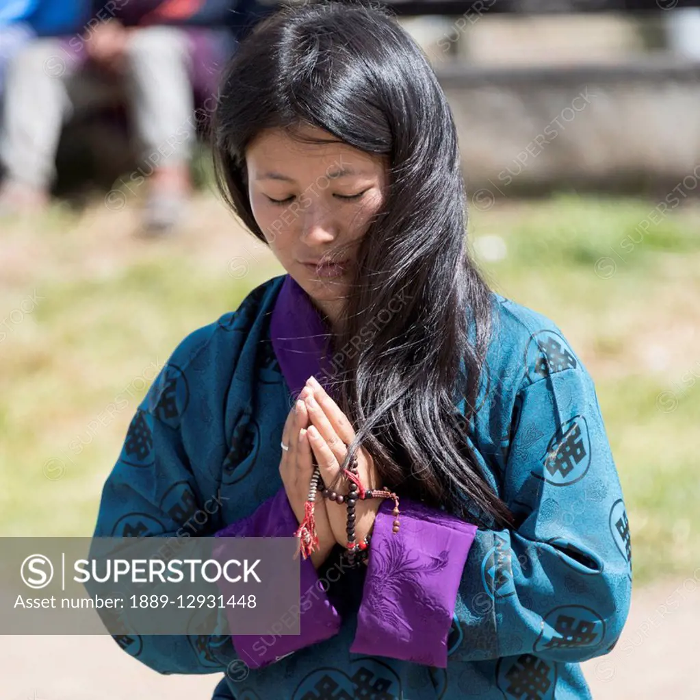 A young buddhist woman praying; Thimphu, Bhutan