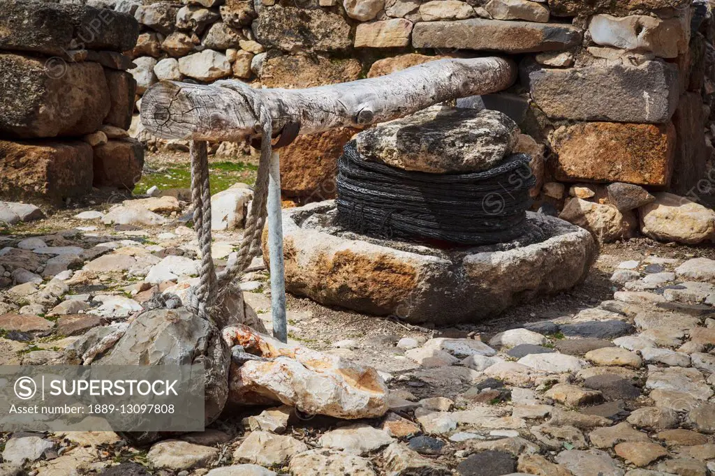 Olive press and stone basin at the site of ancient ruins; Tel Hazor, Israel
