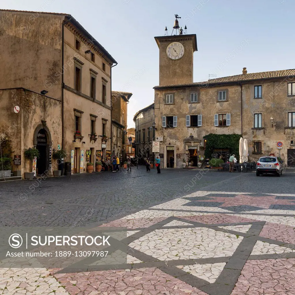 Clock tower and decorative stonework in star of david design on the street; Orvieto, Umbria, Italy