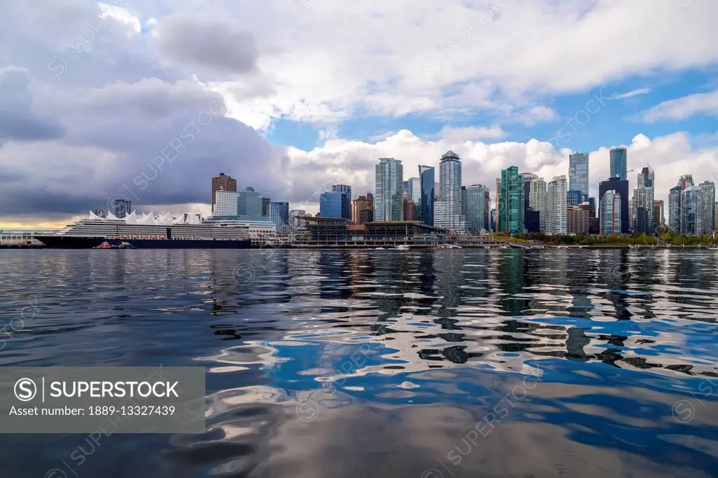 The downtown Vancouver skyline as viewed from the water in Burrard Inlet with a cruise ship docked in the port and the conference centre in the centre...