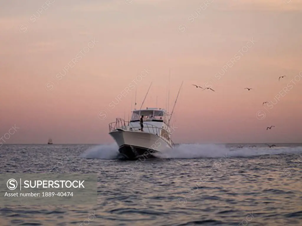 Fishing boat approaching Cabos San Lucas at sunset; Los Cabos, Mexico