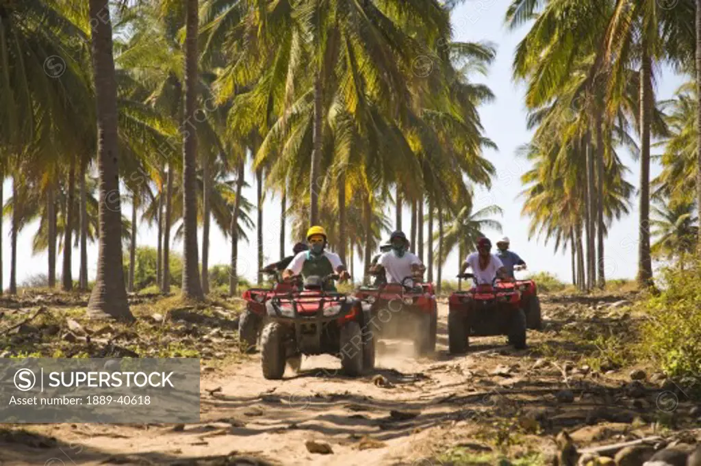 Drivers on quadbikes taking part in  ATV Tour; Stone Island, Mazatlan, Sinaloa, Mexico