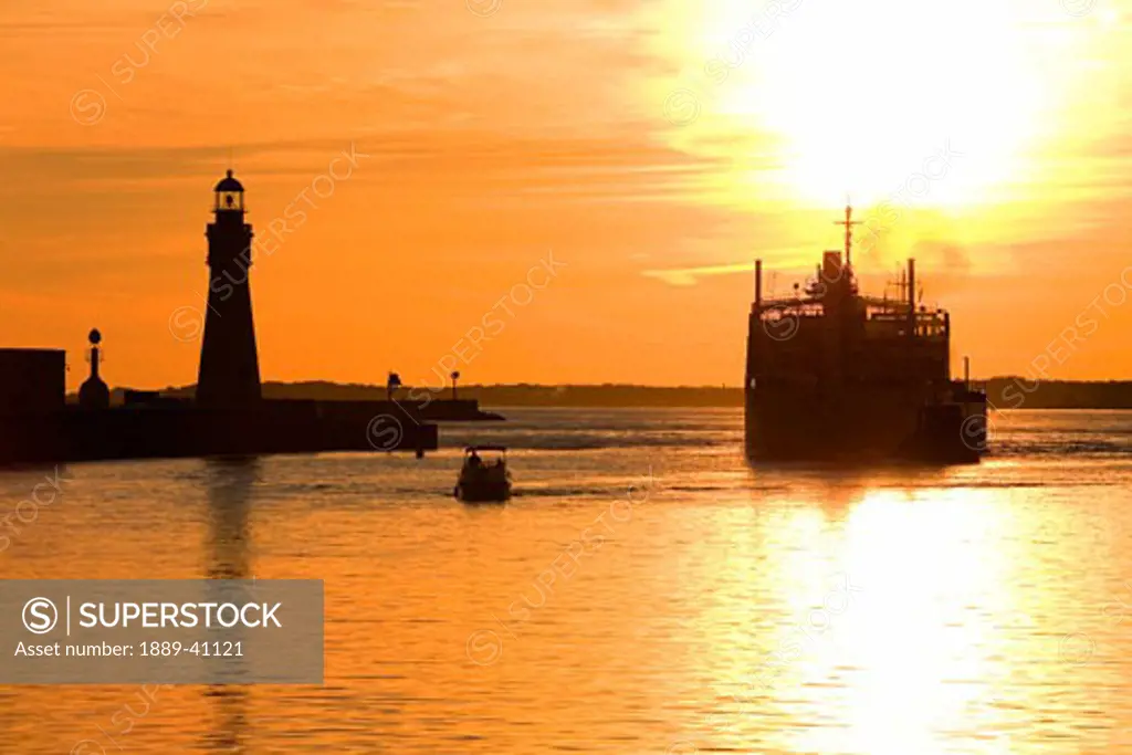 Buffalo Lighthouse and Cement Carrier in Buffalo Port at sunset; Buffalo, New York State, USA