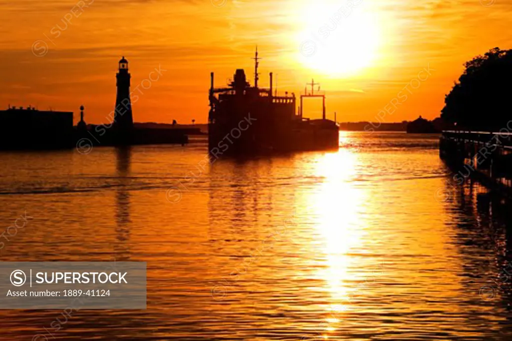 Buffalo Lighthouse and Cement Carrier in Buffalo Port at sunset; Buffalo, New York State, USA
