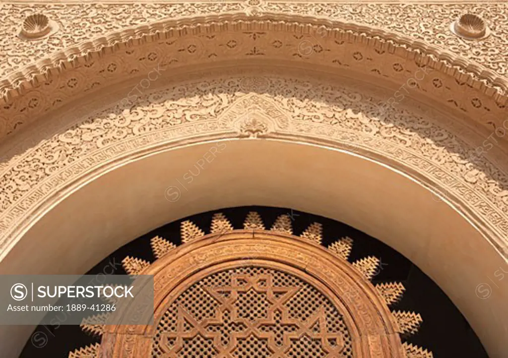 Detail of wooden lattice and stucco work on doorway at Ali Ben Youssef Medersa; Marrakech, Morocco