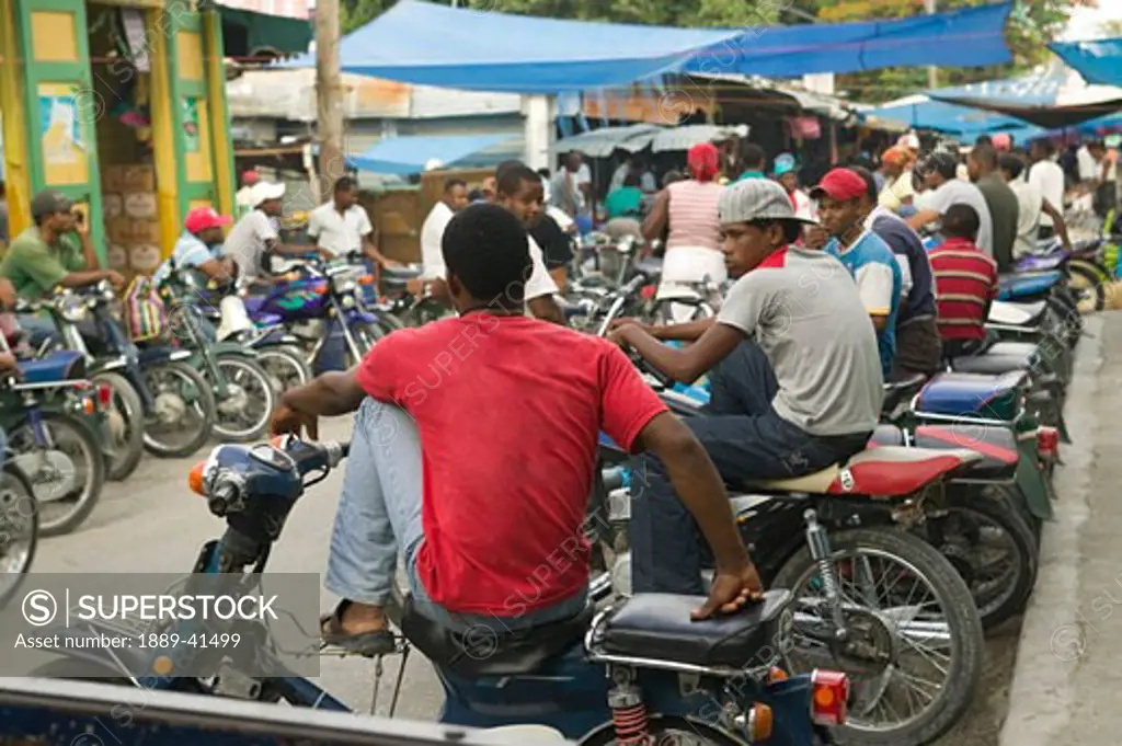 Motorcycle taxi waiting for passenger at street market; Neiba, Baoruco, Dominican Republic