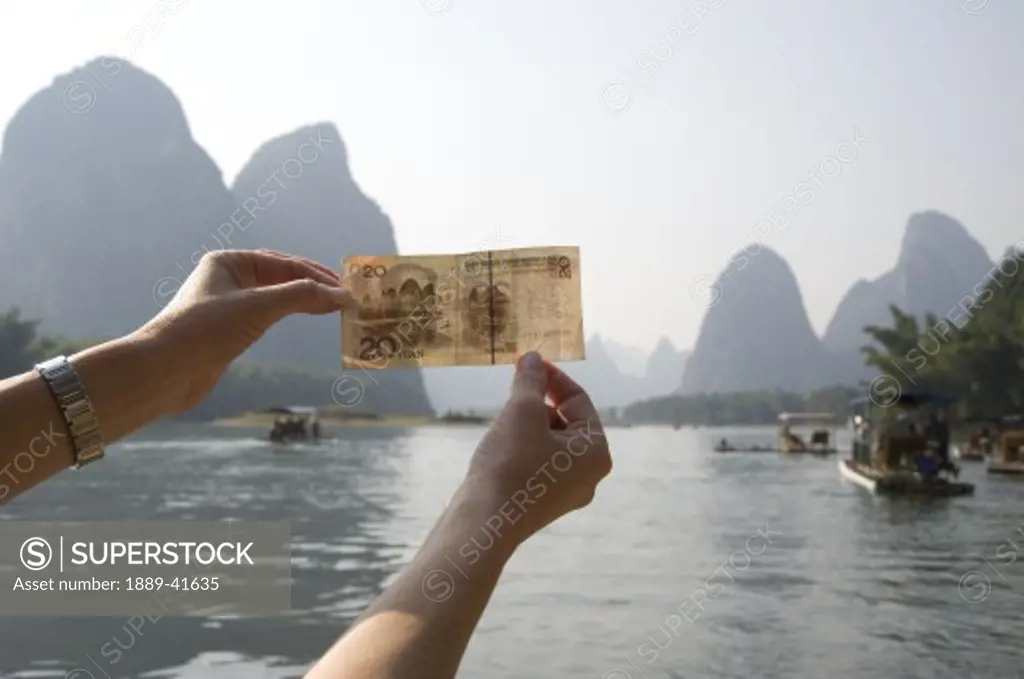 Li River, Yangshuo, China; Person holding up Chinese currency