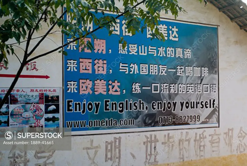 Billboard advertising language school on wall; 