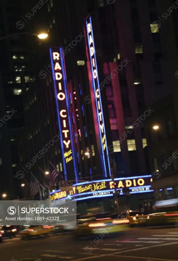 Radio City Music Hall, Manhattan, New York City, USA; Traffic going by theatre at night