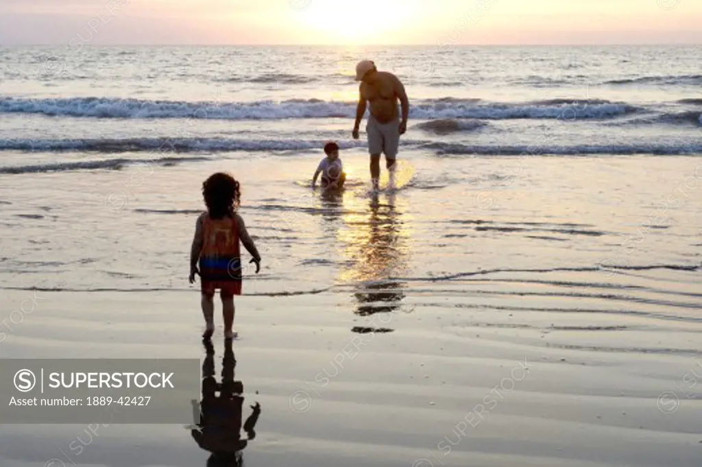 Puerto Vallarta, Mexico; Father on beach with children at sunset