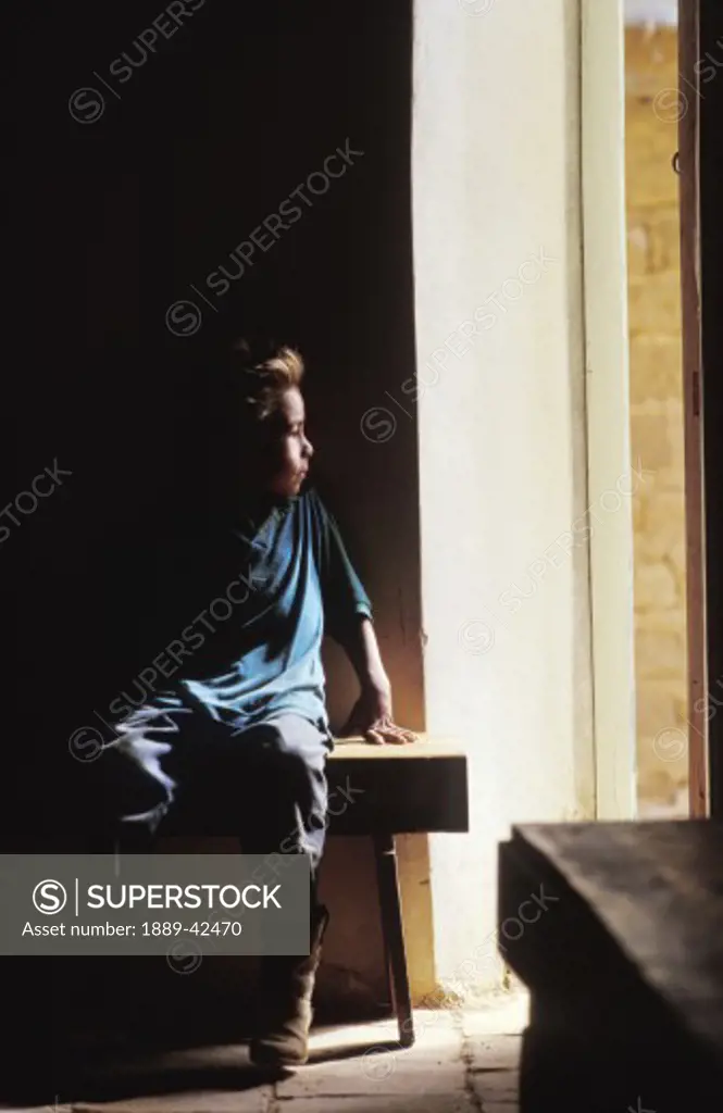 Child sits in the dark