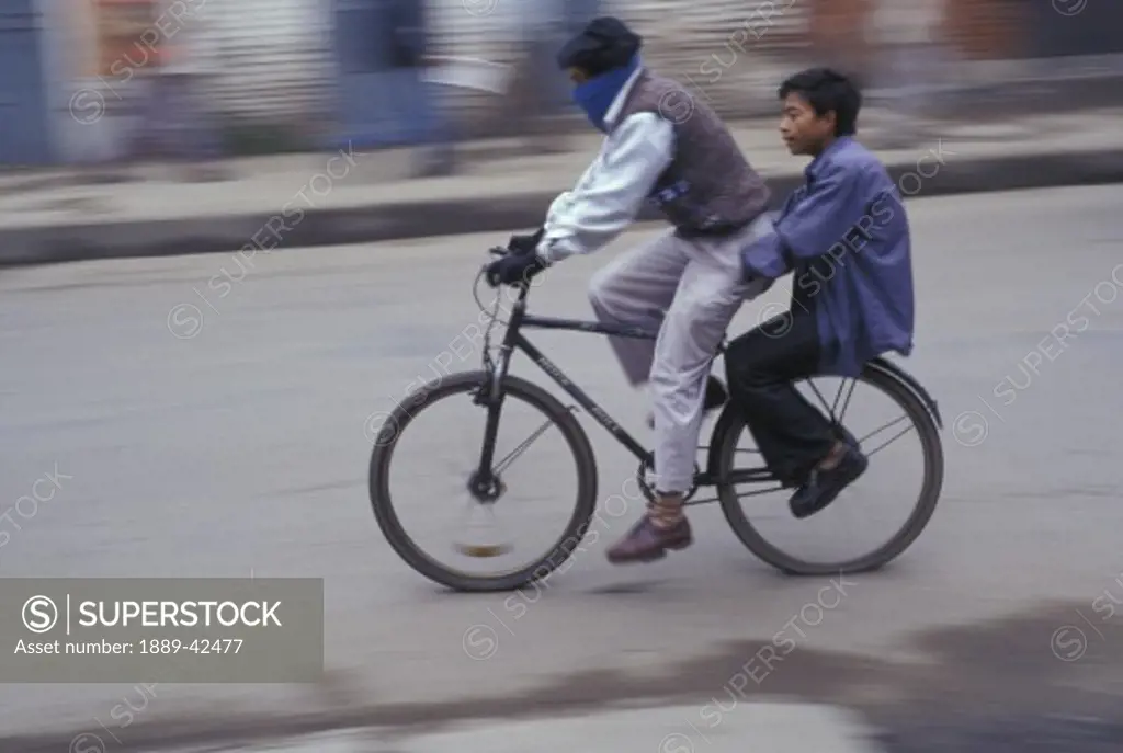 Two men riding a bike