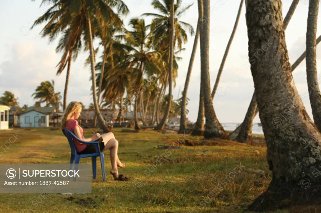 Tasbapauni, Nicaragua; Woman writing overlooking beach
