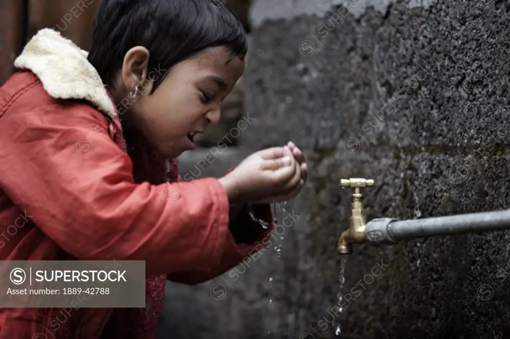 Pokhara, Nepal; Orphaned girl washing at orphanage