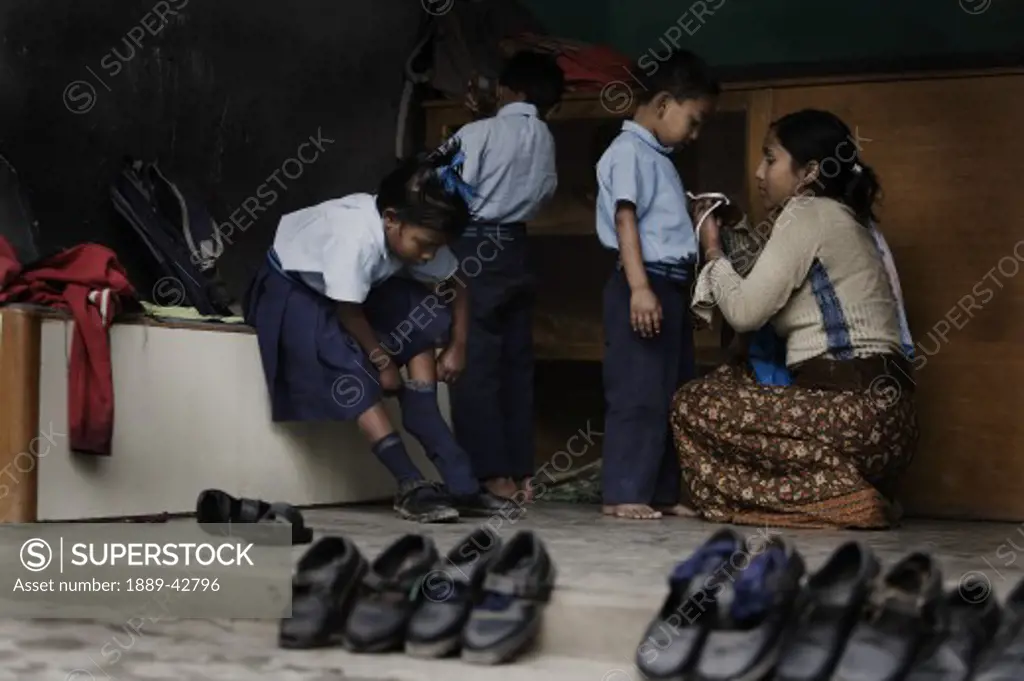 Pokhara, Nepal; Orphan at orphanage getting dressed for school