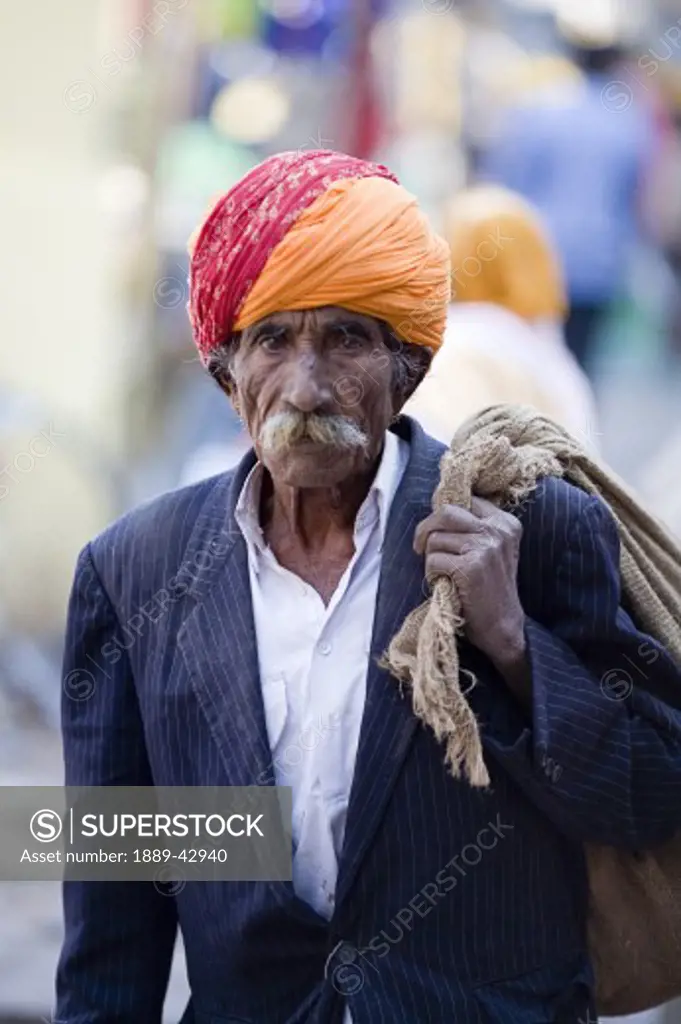 Jodhpur, India; Man carrying sack cloth over shoulder