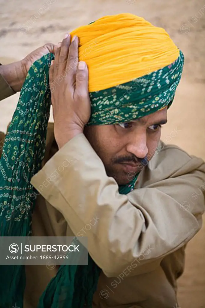 Jodhpur, India; Portrait of man tying his turban