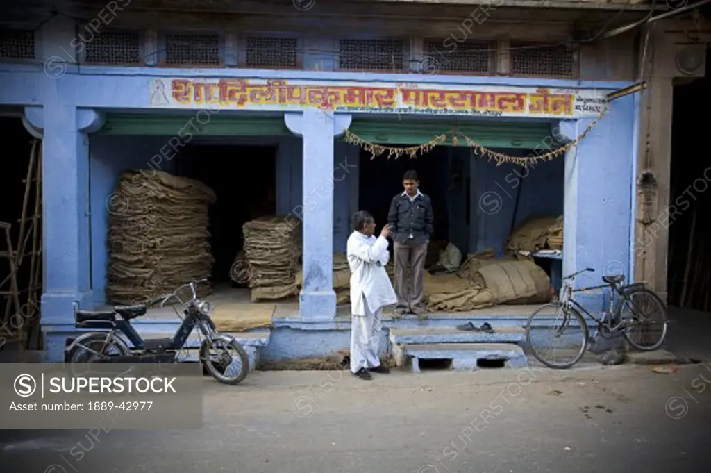 Jodhpur, India; Men standing outside store front talking