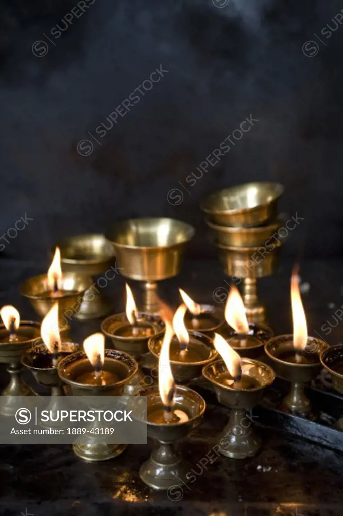 Boudhnath, Kathmandu, Nepal; Candles burning in a row