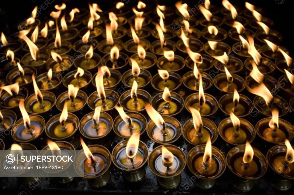 Boudhnath, Kathmandu, Nepal; Candles burning in rows