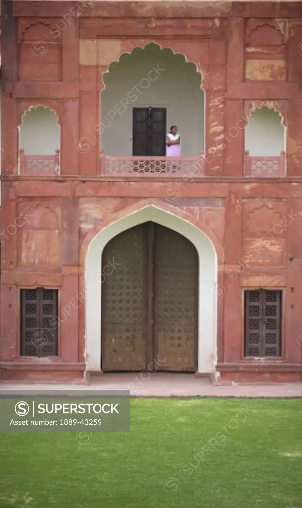 Agra Fort, Agra, India; Woman standing on balcony