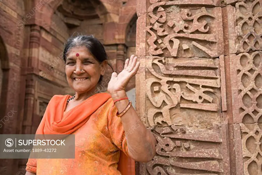 Delhi, India; Woman smiling and waving at camera
